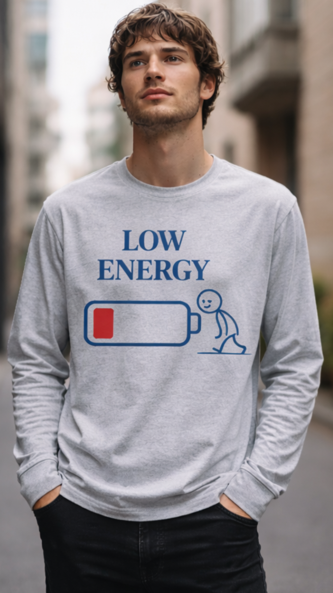 Mann trägt weißes LOW ENERGY Organic Longsleeve T-Shirt mit blauem Print und rotem Batteriestand, modernes Casual-Outfit in Alltagsszene