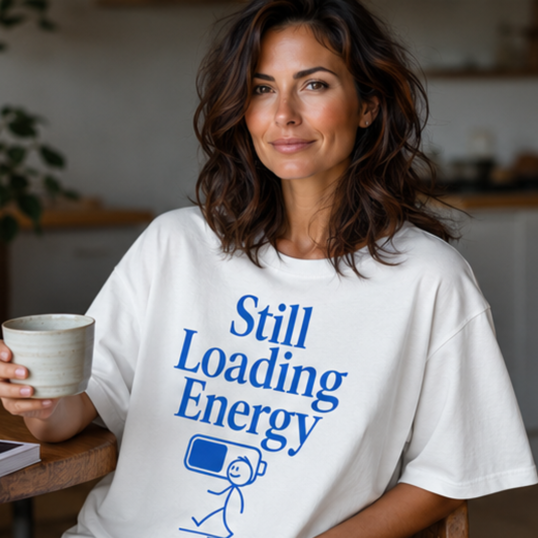 Weibliches Model trägt weißes Oversize T-Shirt mit blauem „Still Loading Energy“-Print, lockerer Unisex-Schnitt